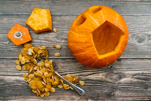 Calabaza de Halloween tallada con pepitas sobre fondo de madera