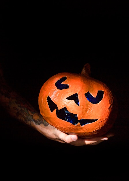 Calabaza iluminada por el sol con cara azul tallada