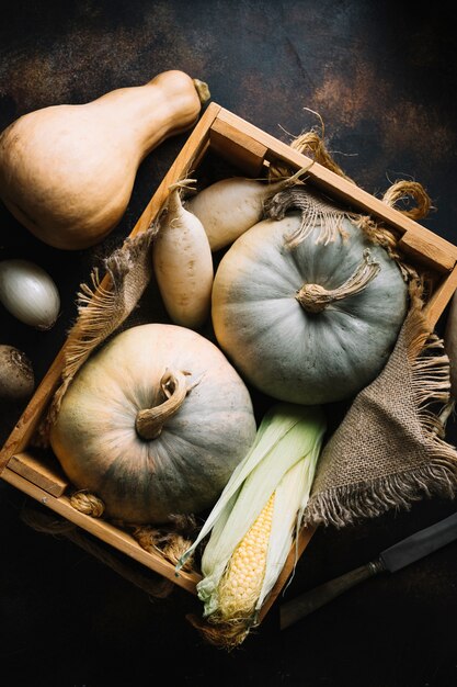 Calabaza y maíz en una canasta de madera.