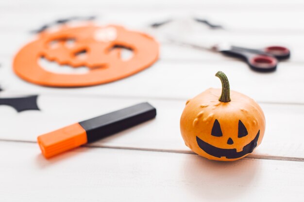 Calabaza con sonrisa negra sobre la mesa