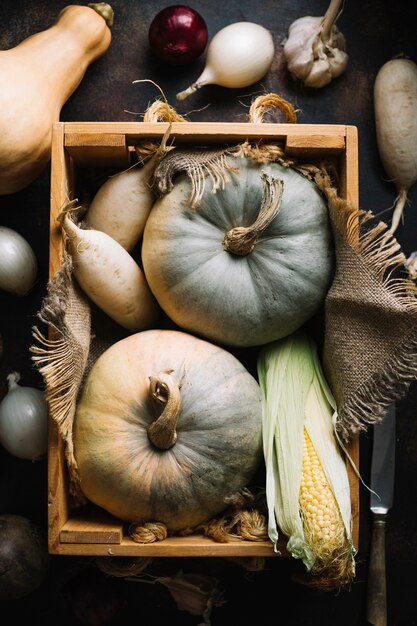 Calabazas y calabazas en canasta de madera con tela de arpillera