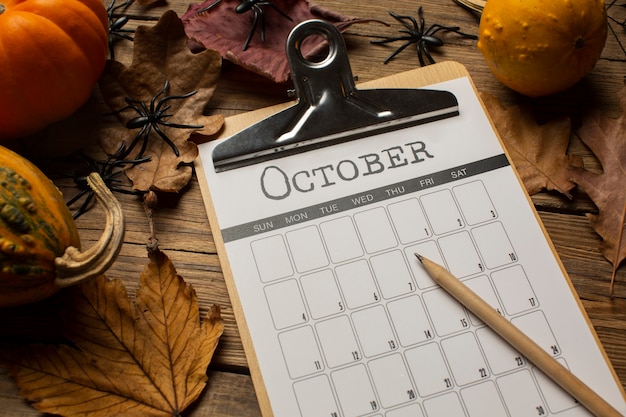 Foto gratuita calabazas y calendario de octubre de alto ángulo