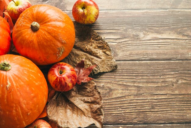 Calabazas de otoño en mesa de madera con hojas