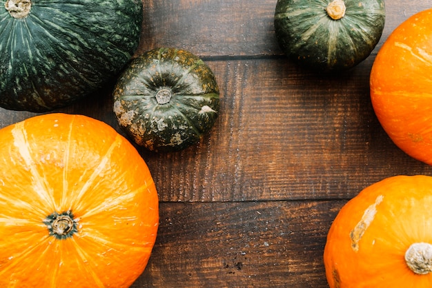 Calabazas verdes y naranjas en la mesa