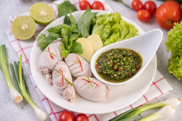 Calamar relleno de cerdo cocido con salsa de mariscos.