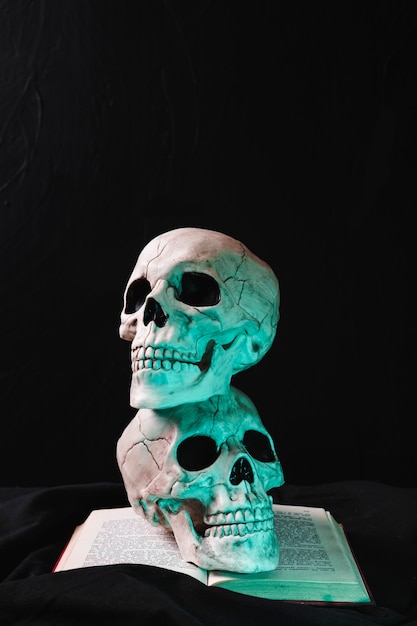 Foto gratuita calaveras iluminadas en libro abierto