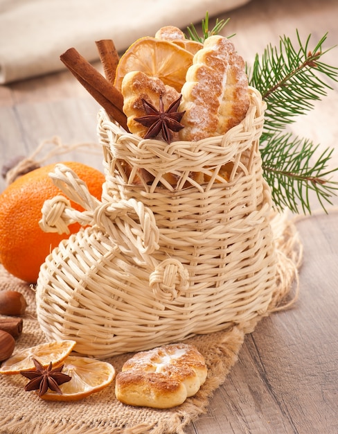 Calcetín de Navidad de mimbre lleno de galletas, canela, limón confitado y anís estrellado