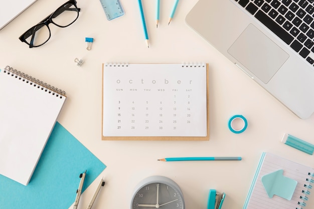Foto gratuita calendario de escritorio plano con accesorios de oficina azul