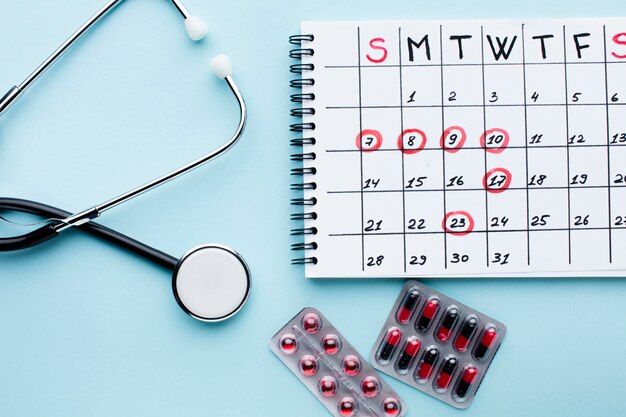 Calendario de tratamiento médico con estetoscopio y pastillas.