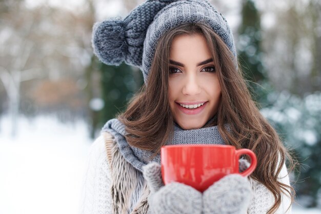 Calentamiento de hermosa mujer joven en invierno