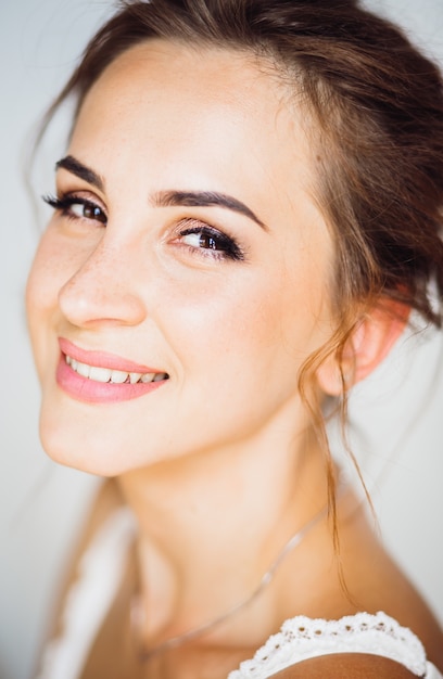 Cálido retrato de la hermosa joven morena con una tierna sonrisa