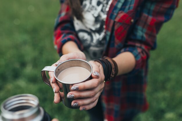 Caliente taza de café caliente calentamiento en las manos de una niña