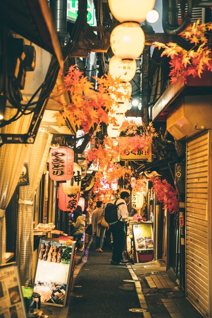 Calle de noche en la ciudad con luces y gente.