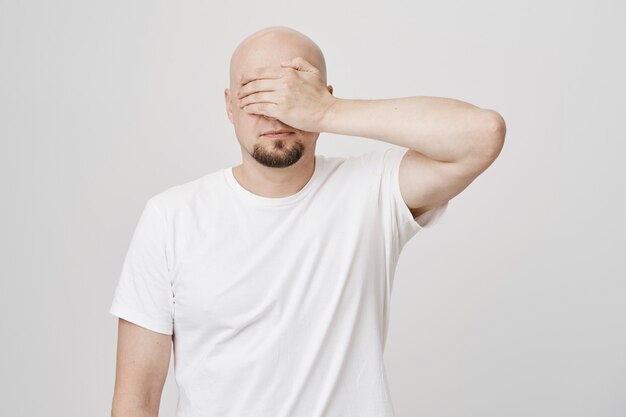 Calma chico barbudo calvo de mediana edad cerró los ojos con la palma