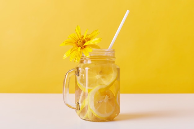 Calma fría de la sed del verano con rodajas de limón y paja