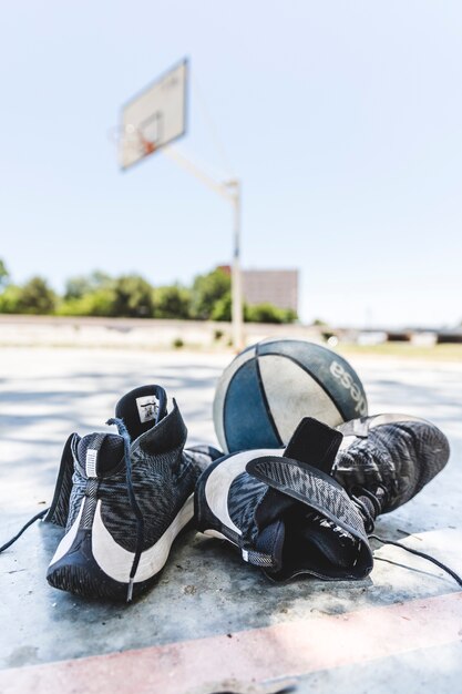 Calzado deportivo y baloncesto en cancha al aire libre
