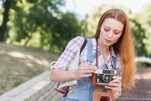 Foto gratuita cámara de configuración de mujer en el parque