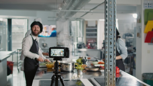 Cámara profesional grabando contenido de programas de cocina con chefs en la cocina del restaurante, filmando a personas haciendo recetas de comida con ingredientes frescos. Clase online de cocina gastronómica.