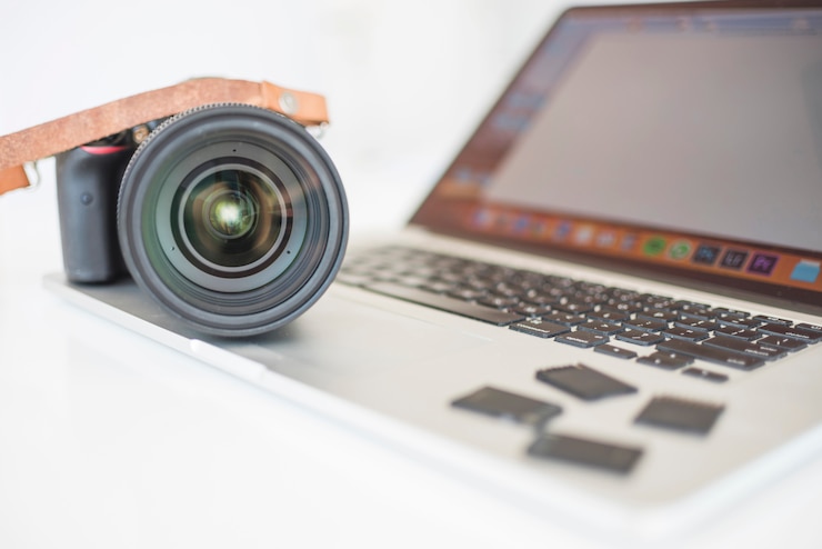 Foto gratuito cámara profesional moderna y tarjetas de memoria en laptop.