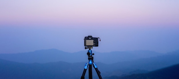 Cámara en trípode Los fotógrafos toman vistas panorámicas con fondo de montaña