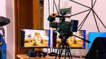 Foto gratuita cámara de video profesional en un soporte con monitores sobre una mesa en un estudio. producción virtual