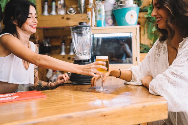 Camarera dando una cerveza a mujer