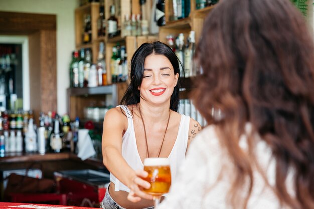 Camarera dando cerveza a mujer