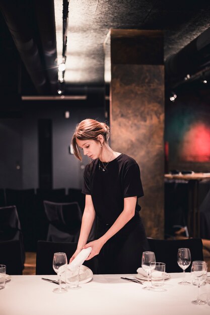 Camarera poniendo el plato y la servilleta en la mesa