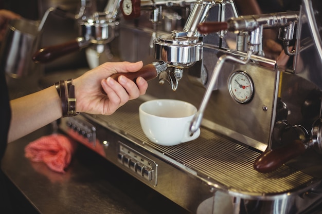 Camarera preparando una taza de café