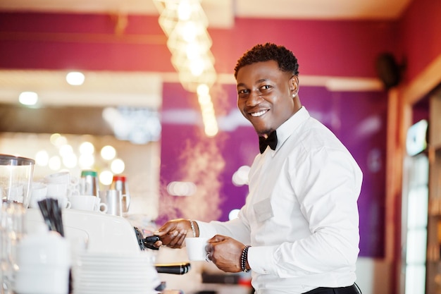 Camarero afroamericano barista en el bar preparando café