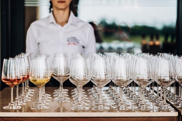 un camarero se para detrás de muchos vasos