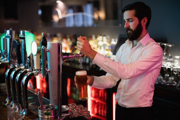 Camarero llenando cerveza de bar pump