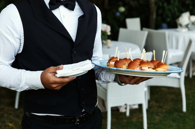 Foto gratuita camarero lleva placa con deliciosos aperitivos