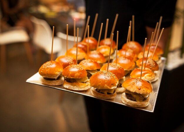 Mini hamburguesas de queso con verduras en la mesa de madera ...