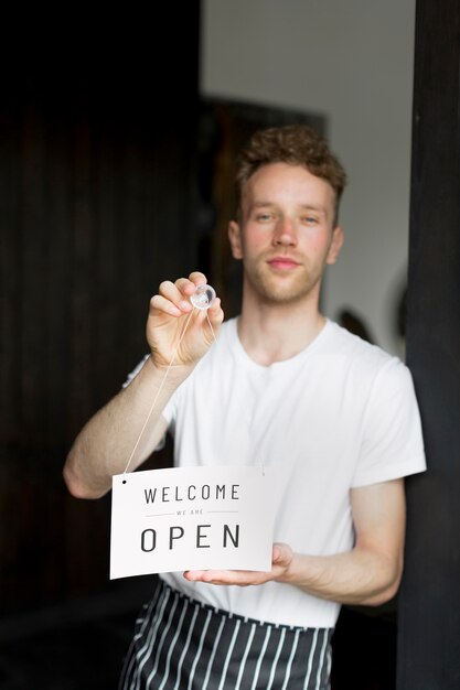 Camarero masculino con cartel de bienvenida