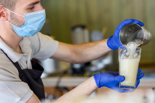 Foto gratuita camarero de primer plano con guantes y máscara en el trabajo