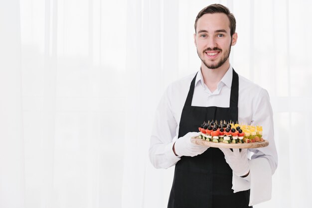 Camarero profesional presentando aperitivos