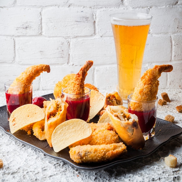 camarones rebozados con salsa y patatas fritas y cerveza en un plato