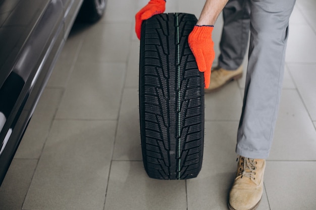 Foto gratuita cambio de neumáticos mecánico en un servicio de automóvil