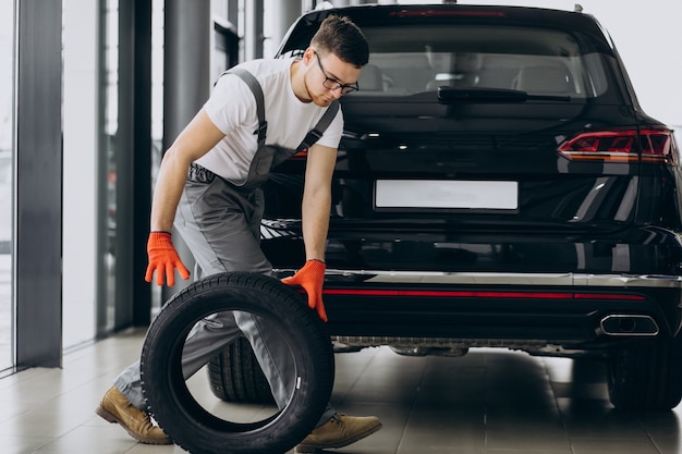 Foto gratuita cambio de neumáticos mecánico en un servicio de automóvil