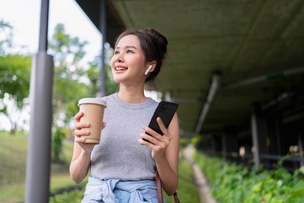 Caminar casualmente mientras se habla de negocios en el corredor de la oficinaNómada digital mujer asiática empresaria independiente trabajo informal mientras viaja vacaciones corredor al aire libre lugar de trabajosonriente teléfono inteligente femenino