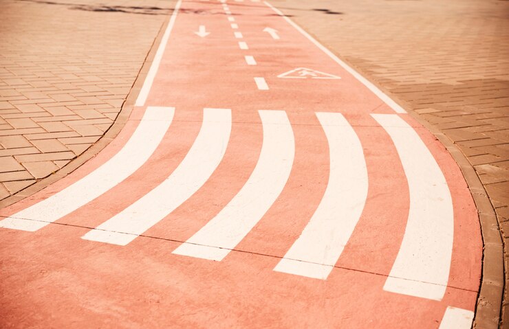 Foto gratuito caminata cruzada y signo de flecha direccional en carril bici con pavimento