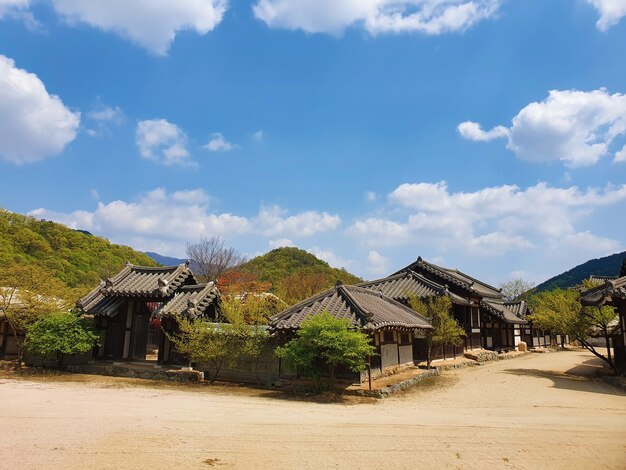 Camino en medio de los edificios de la aldea coreana bajo un cielo azul