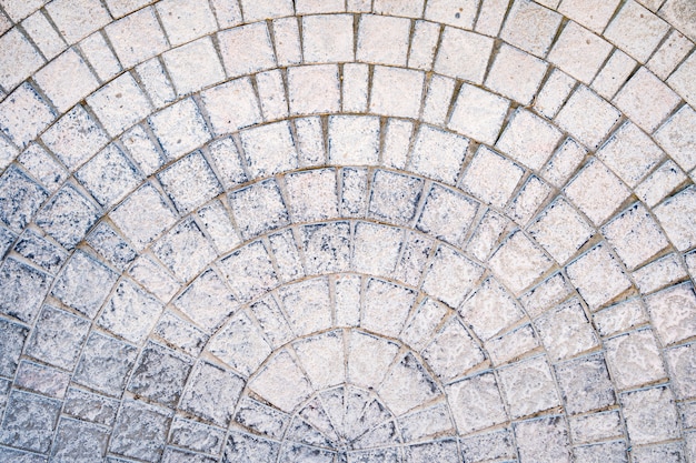 Camino pavimentado de adoquines arqueados con cursos de borde en la textura de la acera