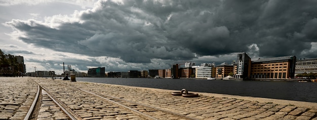 Foto gratuita camino de piedra rodeado de edificios bajo un cielo nublado oscuro