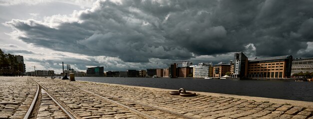 camino de piedra rodeado de edificios bajo un cielo nublado oscuro