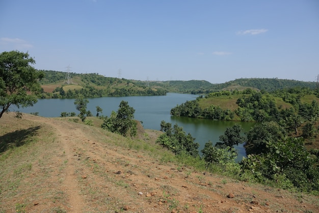 Camino de tierra con un lago al lado