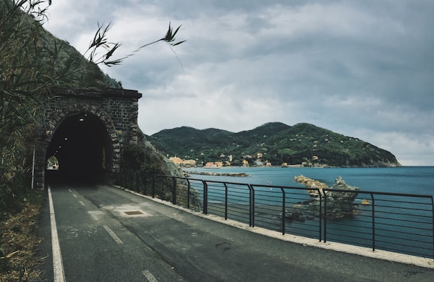 Foto gratuita camino hacia un túnel en la montaña cerca de un mar con montañas