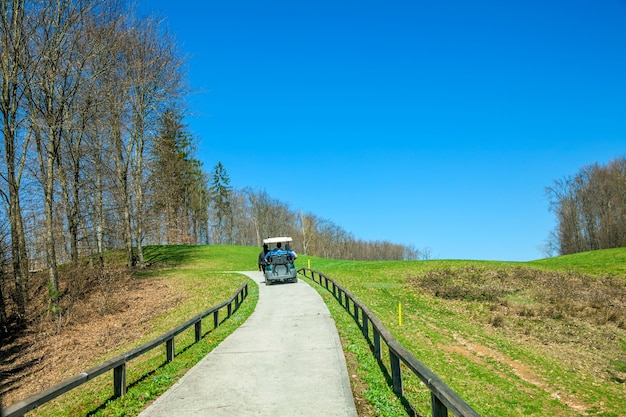 Camión de golf cabalgando por el camino en el campo de golf en Otocec, Eslovenia