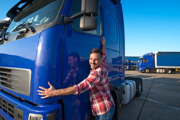 Camionero abrazando su vehículo camión para transporte